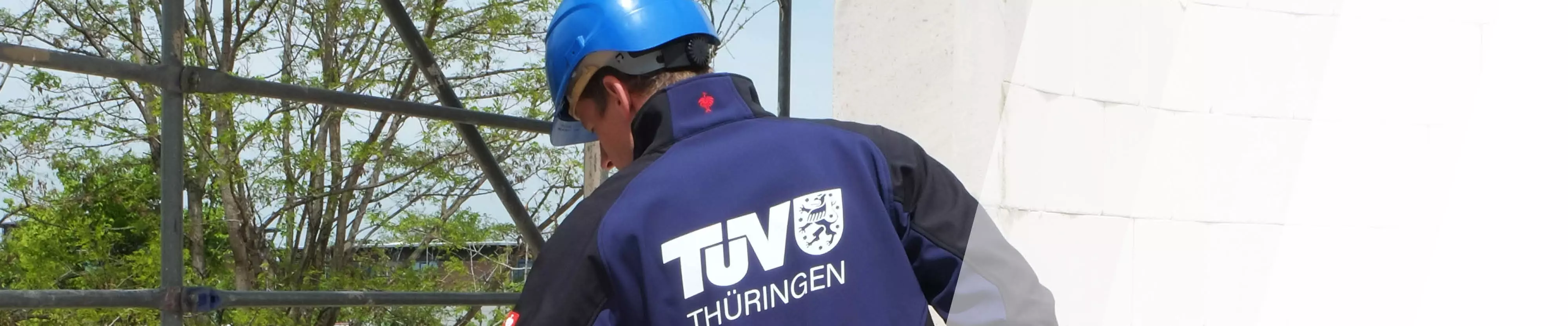 TÜV Thüringen Prüfer mit Helm der etwas inspiziert