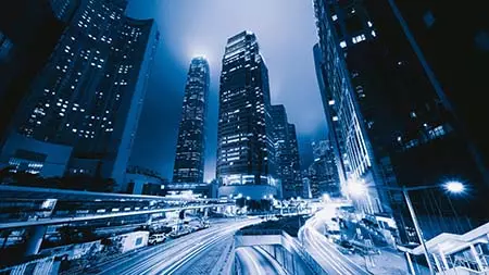 Beleuchtete Straße in einer Großstadt mit Skyline