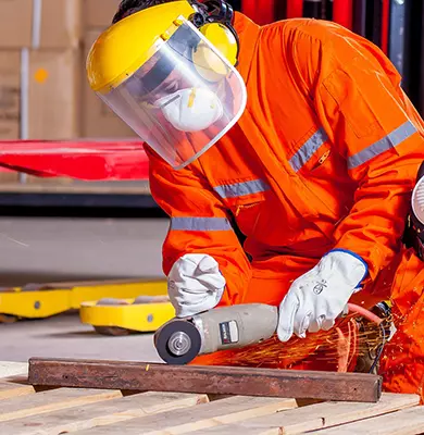 Arbeiter mit Schutzbrille und Handschuhen benutz einen Trennschleifer