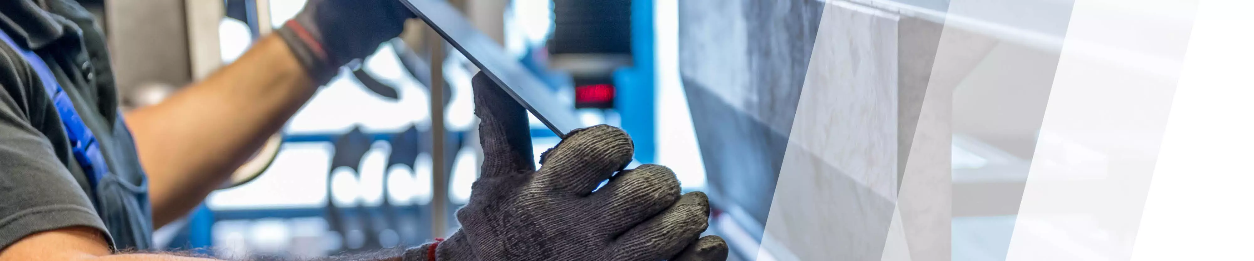 Arbeiter kantet ein Blech an einer Maschine ab
