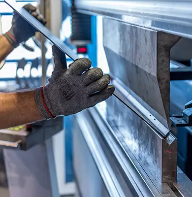 Arbeiter kantet ein Blech an einer Maschine ab